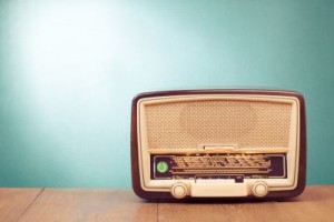 Old retro radio with green eye light on table
